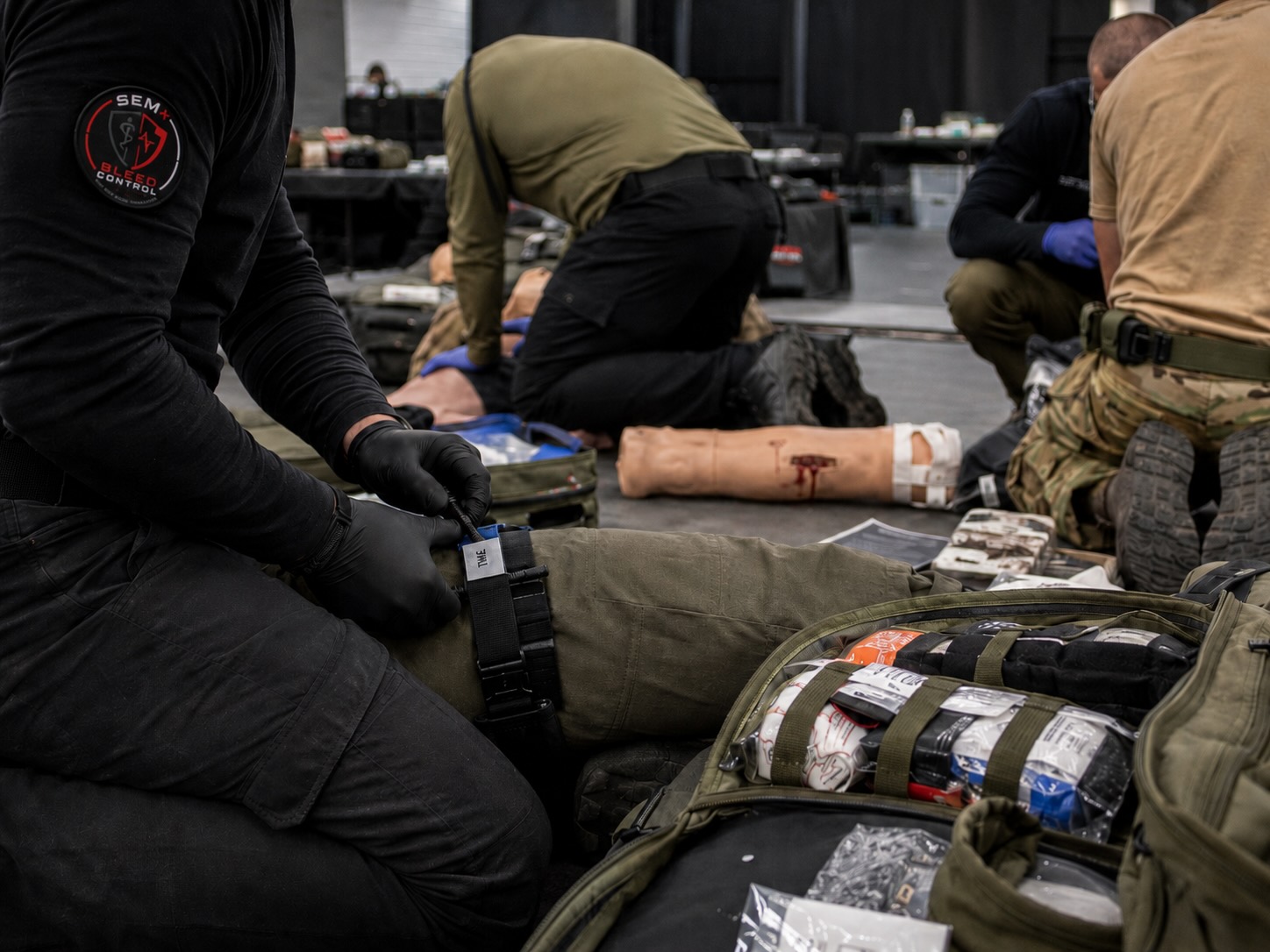Bleed-Control-Schulung in einer Halle mit drei Teilnehmenden beim Training zur Blutungskontrolle und Tourniquet-Anlage